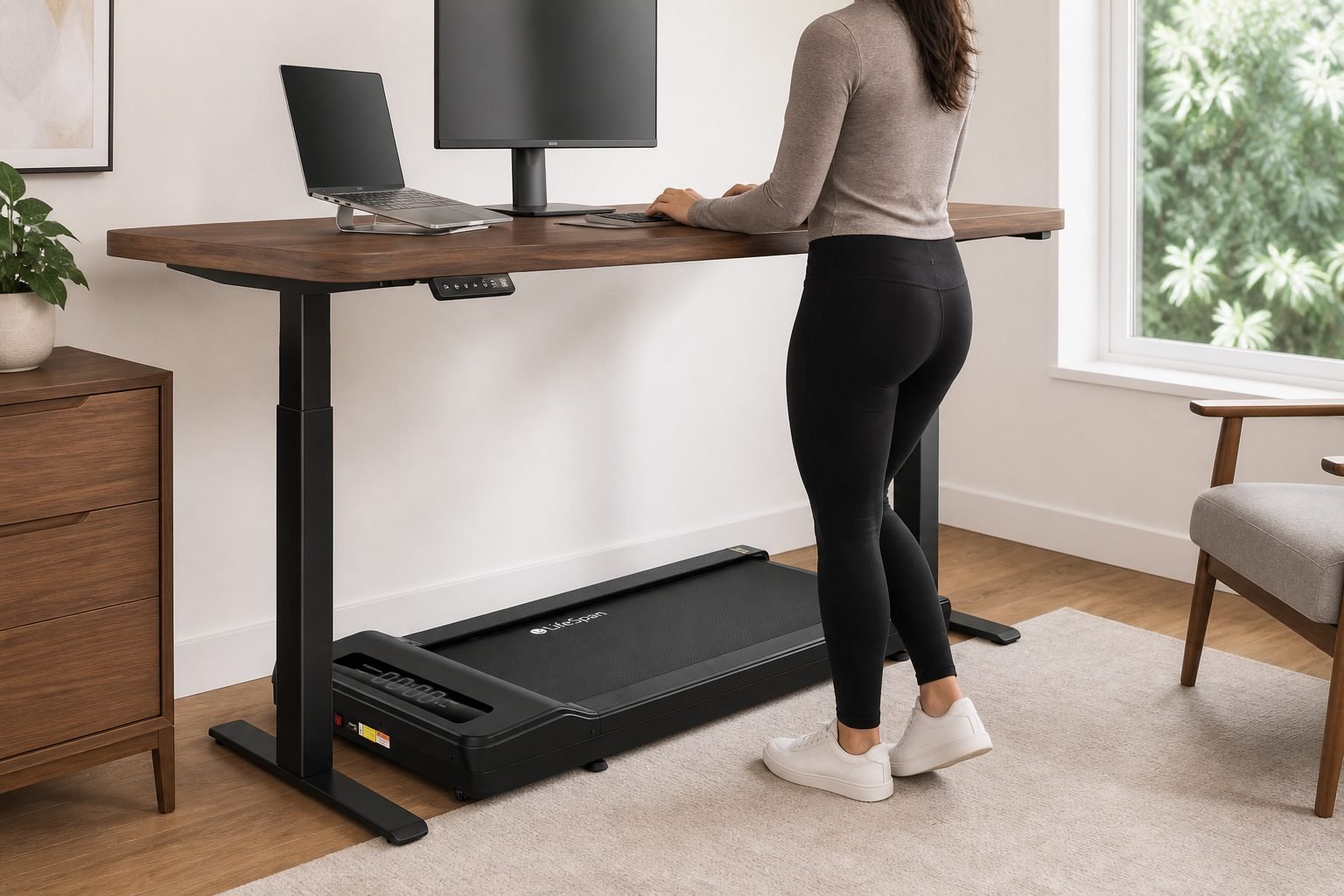 Black LifeSpan TX6 under-desk treadmill under a walnut standing desk in a premium home office