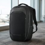 NOMATIC Navigator Travel Backpack 32L in Black standing in a premium airport terminal
