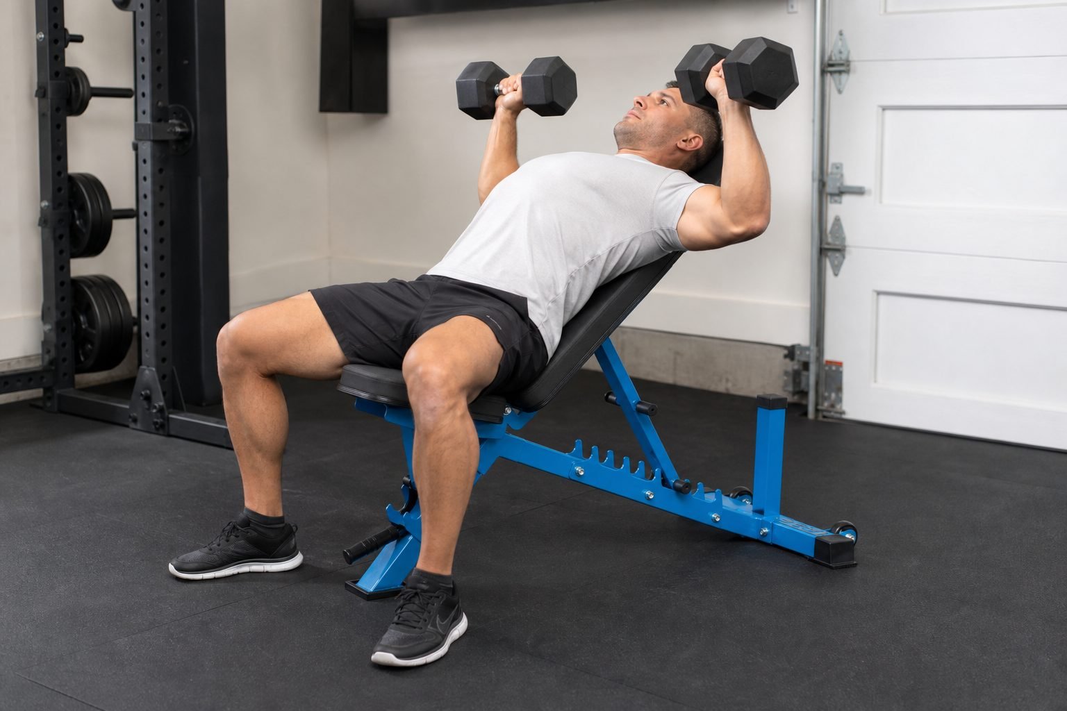 Controlled incline dumbbell press on a REP AB-3100 blue adjustable bench in a home gym