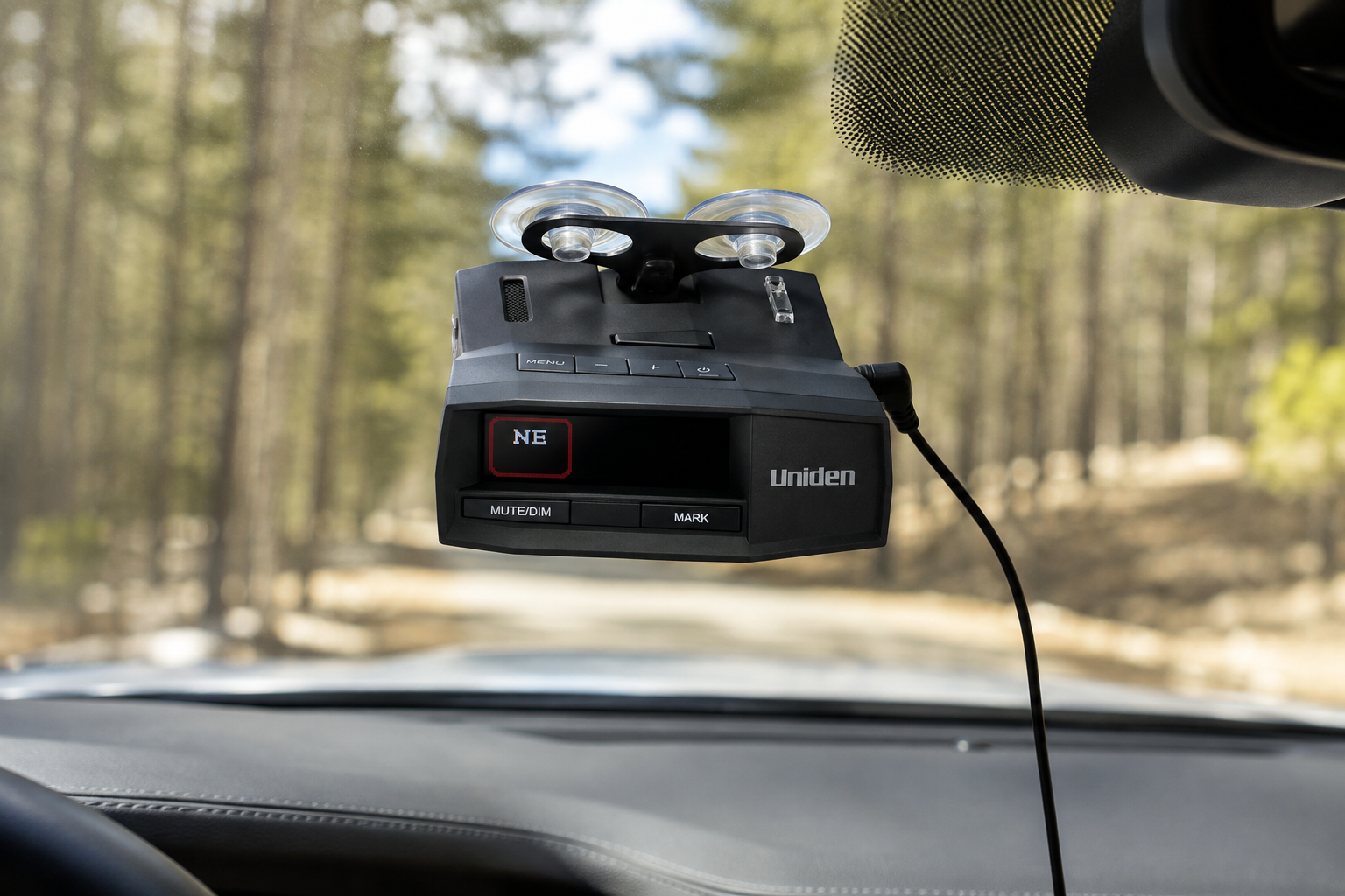 Uniden R8 radar detector mounted on a windshield with power cable