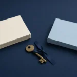 Two stacks of blank cards and a brass key on a navy desk, suggesting a choice between domain registrars