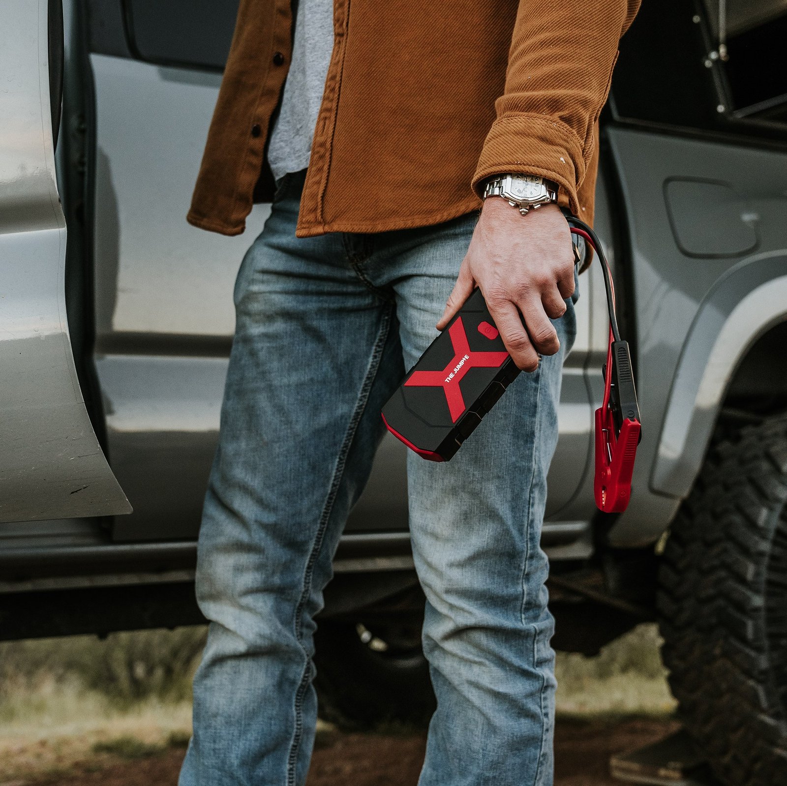 Person carrying a Redi Jumpie with jumper clamps beside an open vehicle door