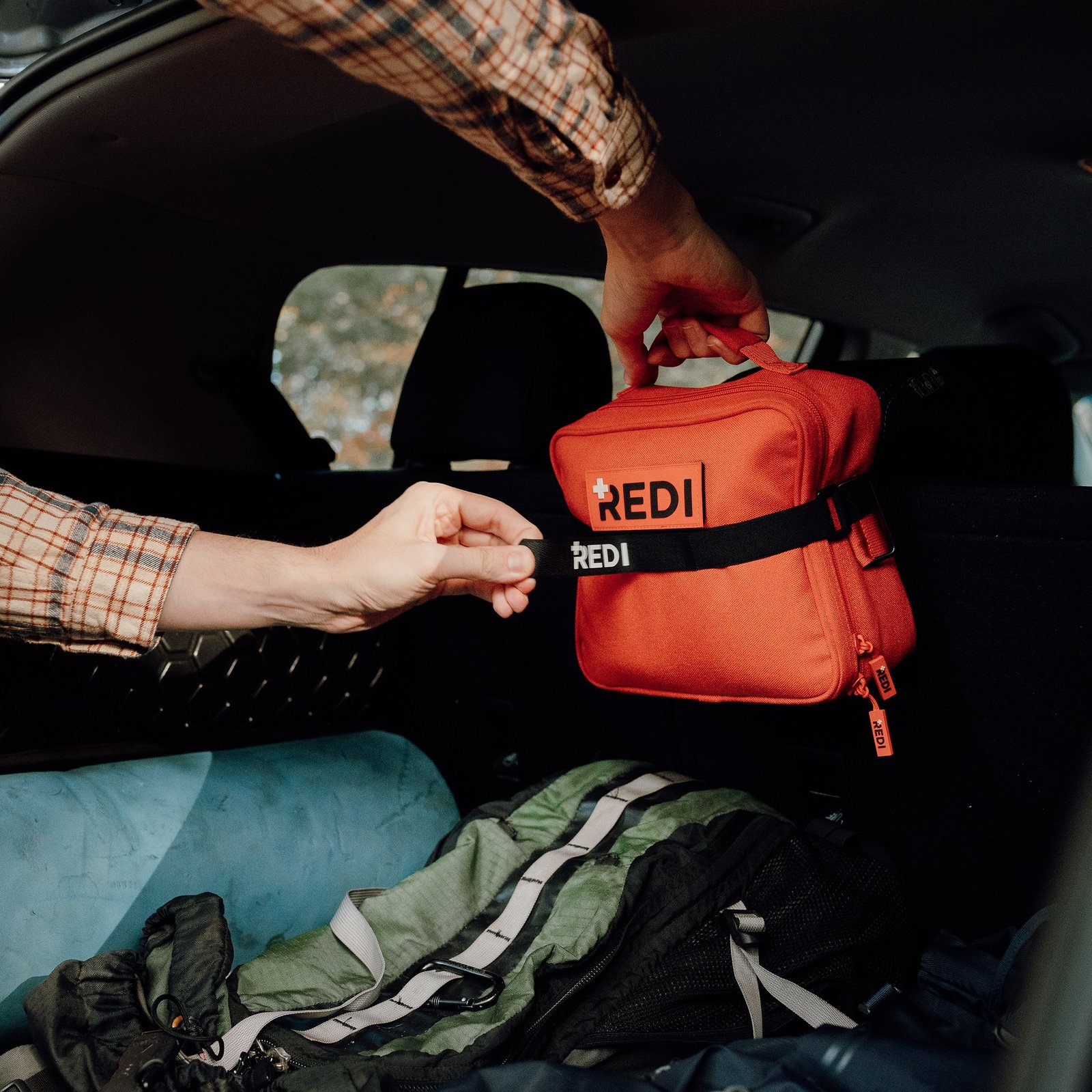Person holding a Redi Roadie in a vehicle with a Redi strap