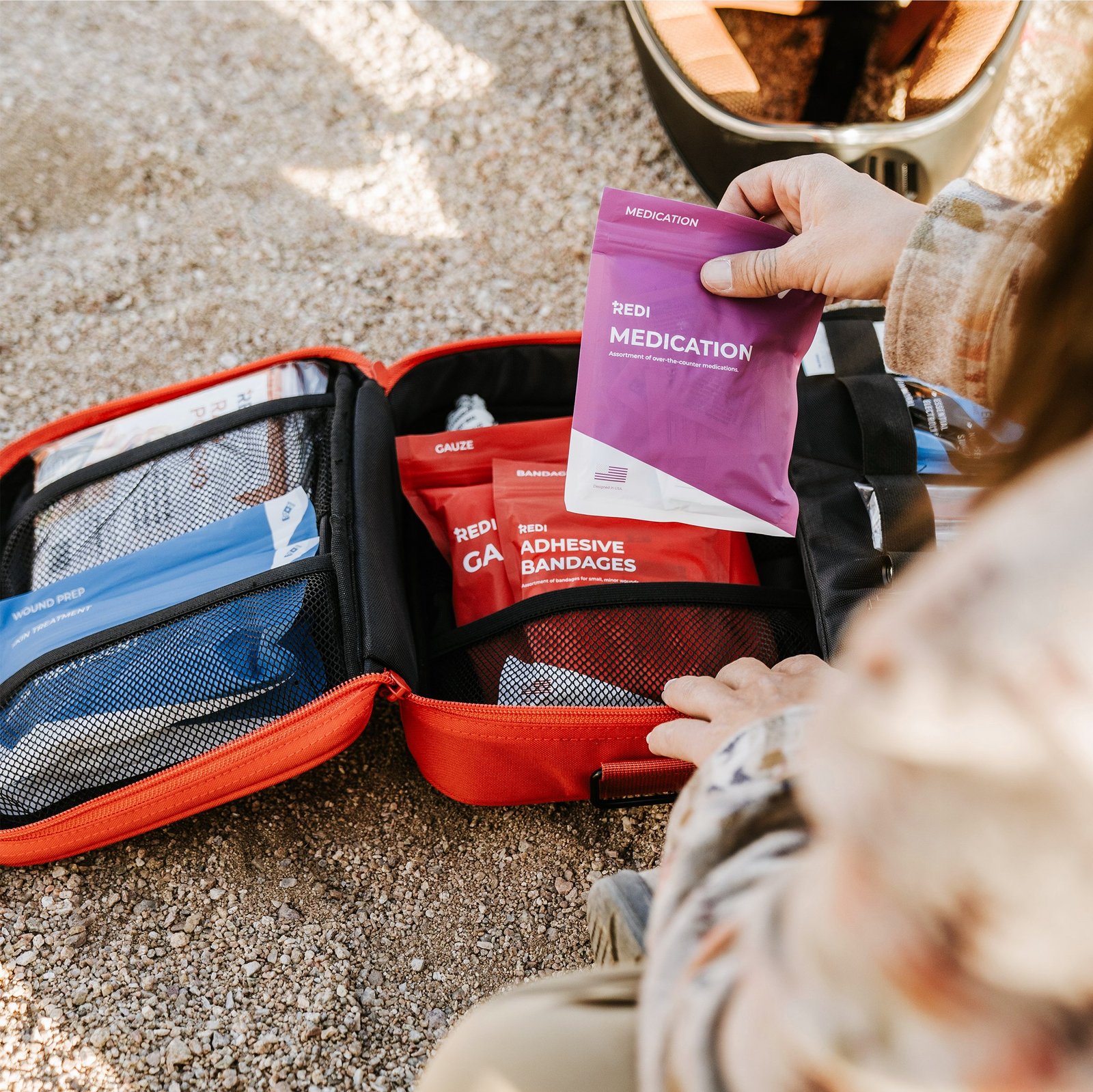 Labeled medication pouch held above an open Redi Roadie